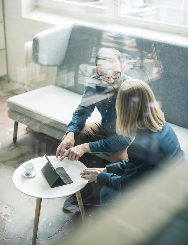 two co-workers talking in office